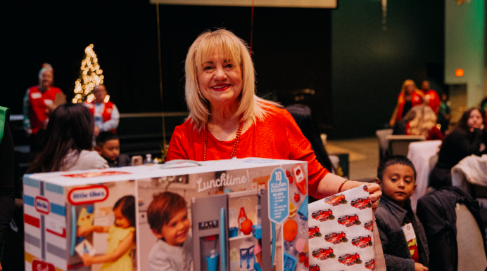Christmas Mall volunteer with donated gifts